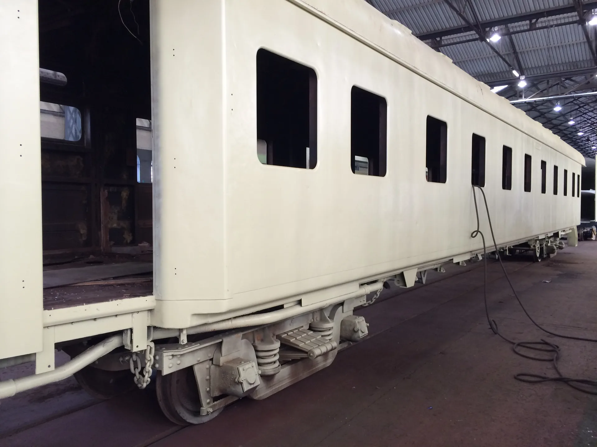 CFB Angola passenger coach refurbishment — primer coat applied, side profile view